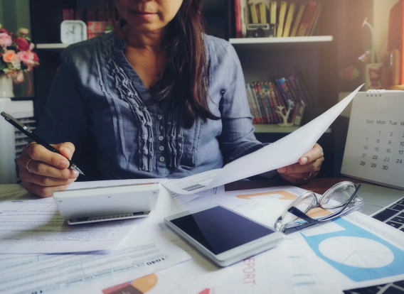 Header - Homes Taxes A woman filling out tax forms